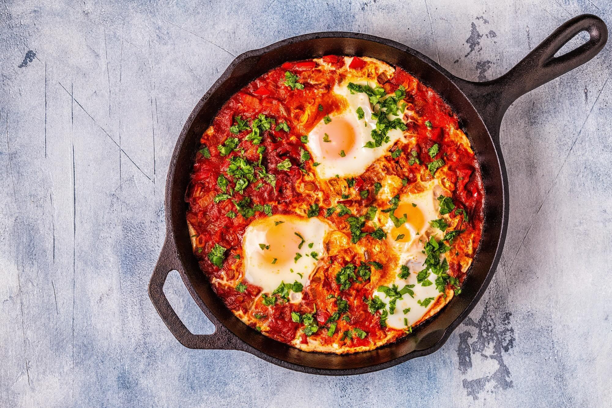 Shakshuka — poached eggs in spiced tomato sauce in cast iron skillet at Perfect Together Philadelphia