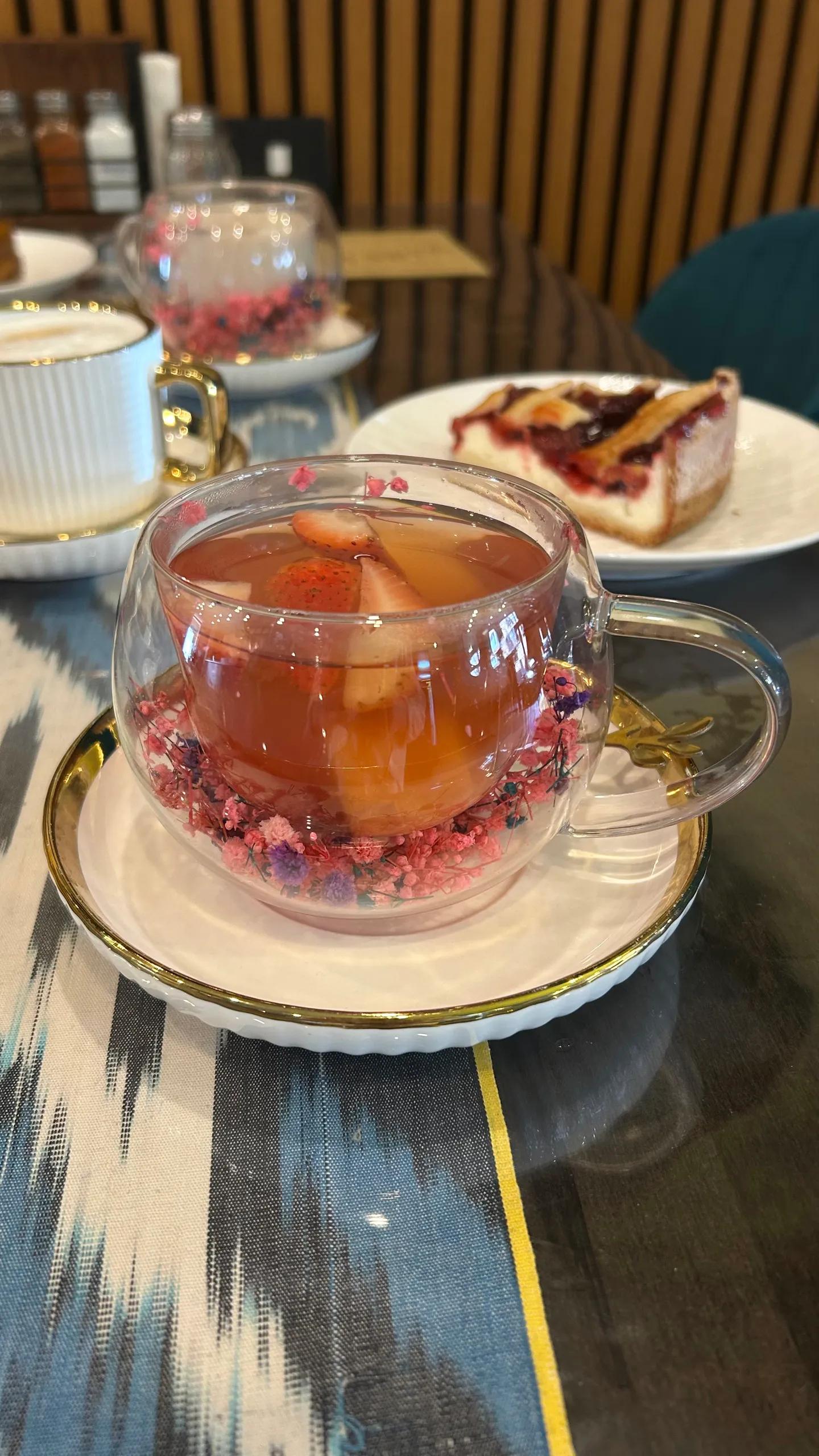 Artisan fruit tea with strawberry in floral glass cup at Perfect Together Cafe Philadelphia